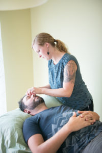 Allie Machen placing acupuncture needles into the face of her male patient.