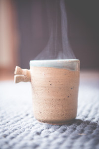 Steaming cup of hot tea in a ceramic handmade mug.