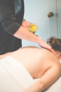 Allie Machen putting healing salve on the back of a female patient.